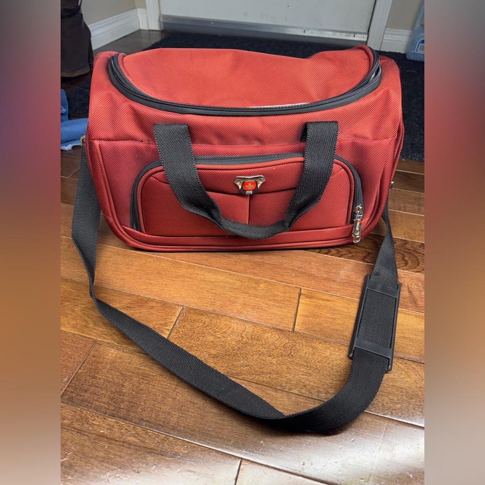 Swiss gear soft sided travel bag to go on suitcase handle in rusty red